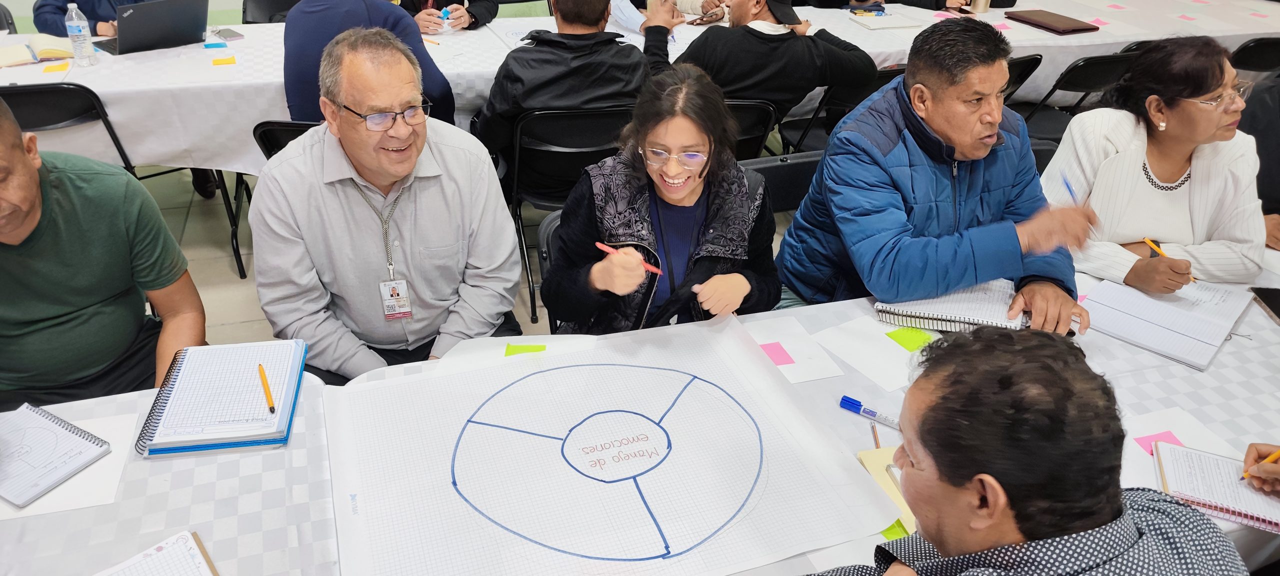 Personas en una reunión, manos levantadas